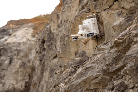 Inspemon industrial monitoring device mounted on a cliff for real-time infrastructure and data acquisition.